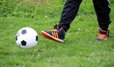 Kinder spielen Fußball im Garten